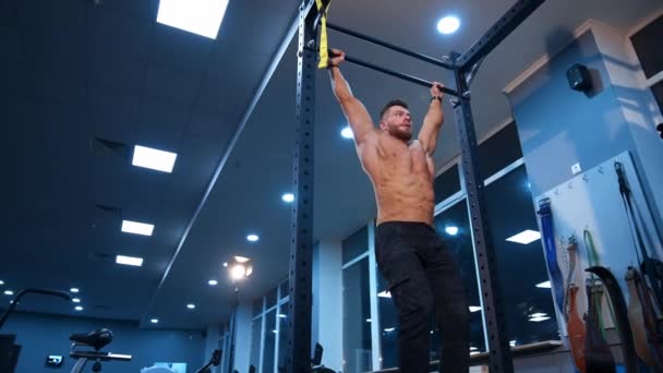 强壮的运动员挺身而出 肌肉男在体操馆的横梁上做运动 — 图库视频影像