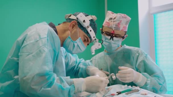病院で手術を行っている医療チーム 手術室で手術中に協力する医師のチーム — ストック動画