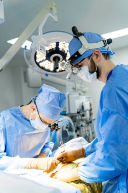 Hastanede bir hastaya ameliyat yapan iki cerrah. Modern bir hastanede beyin cerrahisi yapan cerrahlar