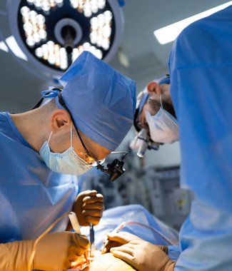 Hastanede bir hastaya ameliyat yapan iki cerrah. Modern bir hastanede beyin cerrahisi yapan iki cerrah.