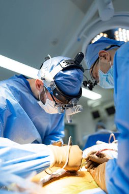 Hastanede bir hastaya ameliyat yapan iki cerrah. Modern bir hastanede beyin cerrahisi yapan iki cerrah.