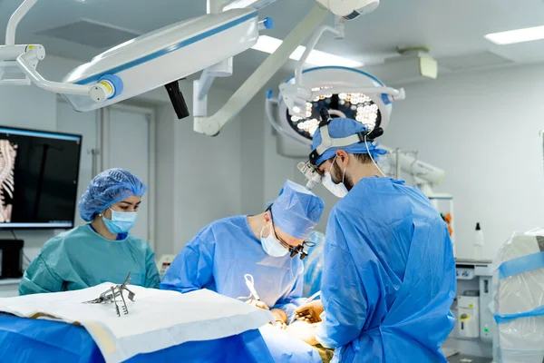 A group of doctors performing surgery in a hospital. Group of Doctors Performing Neurosurgery in a Modern Hospital