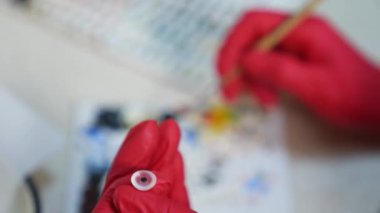 Göz küresinin anatomik modeli. Göz protezi üreten elleri kapatın.