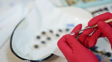 Cam göz protezi, kapat. Oftalmolog elinde göz protezi tutuyor.