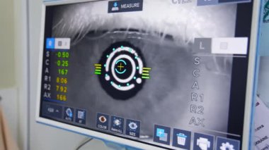 Göz doktoru tarafından muayene edilen adam. Bilgisayar ekranında retina taramasına bakan oftalmolog