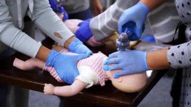 Kardiyopulmoner resüsitasyon öğretiyorum. Bebek eğitim bebeğine kardiyopulmoner canlandırma uygulanıyor.