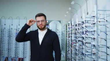 Yeni gözlük deniyorum. Görüş bozukluğu olan genç adam yeni gözlük seçiyor.
