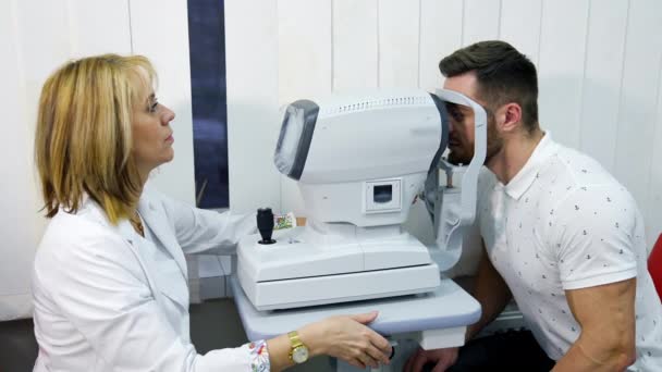 Пациент Офтальмологической Клиники Красивый Молодой Человек Проверяет Зрение Современной Офтальмологической — стоковое видео
