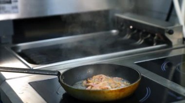 Restoran mutfağında kızartma tavası. Restoranın mutfağında yemek pişiren profesyonel bir aşçı.