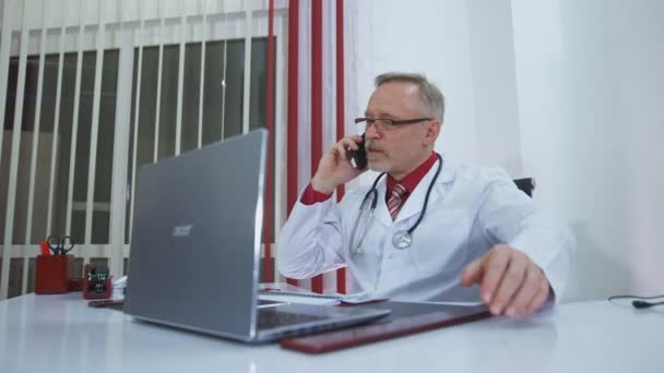 医生在讲手机 在手机上与病人交谈的成熟医生 — 图库视频影像