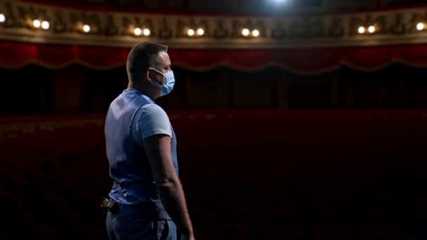 劇場でマスクをする男 保護フェイスマスクの男がステージでパフォーマンス — ストック動画