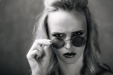 Yüzünde gözlük olan bir kadın resim için poz veriyor. Gözlüklü Şık Bir Kadın Poza Vuruyor