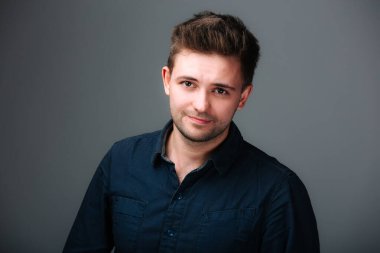 Mavi gömlekli bir adam resim için poz veriyor. Mavi Gömlekli Adam Fotoğraf İçin Pozisyon Veriyor