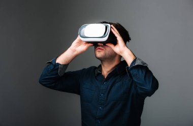 Mavi gömlekli bir adam sanal bir cihaz kullanıyor. Sanal Aygıtla Etkileşen Bir Adam