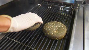Şef restoranda hamburger pişiriyor. Restorandaki muhteşem hamburgerin hazırlıklarına son verelim.