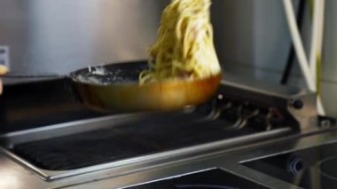 Şef tavayla yemek yapıyor. Şef lokanta mutfağında yemek hazırlıyor.