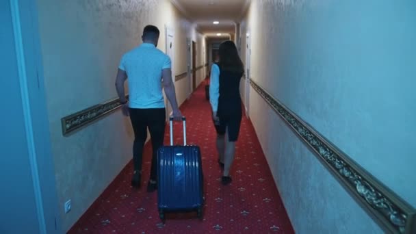 Νεαρό Ζευγάρι Στο Διάδρομο Του Ξενοδοχείου Ζευγάρι Βαλίτσα Περπατώντας Στο — Αρχείο Βίντεο