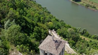 Bir tepenin üstündeki kalenin kulesinin hava görüntüsü. Aşağıda güzel bir nehir akıyor. Videoya seçici odaklanma.