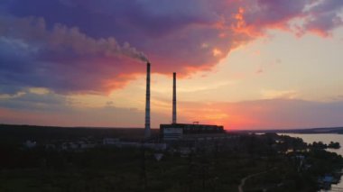 Gün batımında göl manzarasında elektrik santrali. Zaman Ayarı videosu.
