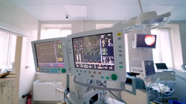 心臓のパラメータを表示する医療スクリーン 医師団がバックグラウンドで手術を進めています 手術中にバイタルを表示する ビデオコンテンツ — ストック動画