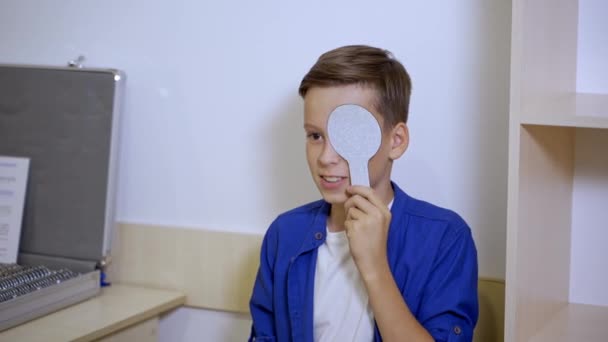 Test Vision Eye Clinic Small Boy Holding Ophthalmology Plate Pediatric — Stock Video