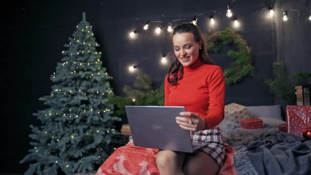 幸せな女性はノートパソコンで冬休みでお祝いを入力しています クリスマス前の幸せな女性 — ストック動画