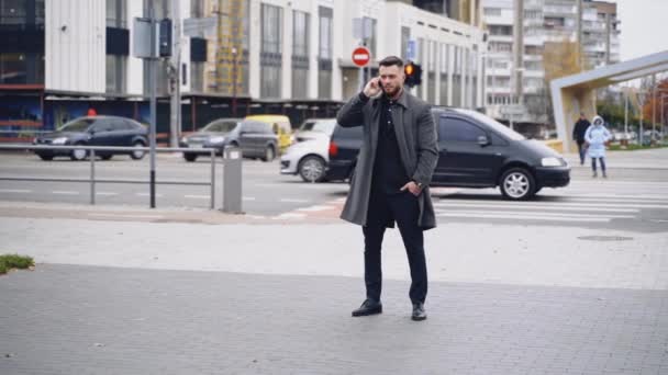 스트리트 스타일 우아한 수트와 코트를 전화에서 말하는 도로를 잘생긴 코카서스 — 비디오