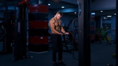 Gömleksiz erkek vücut geliştirici modern spor salonunda eller için egzersiz yapıyor. Yavaş çekim.
