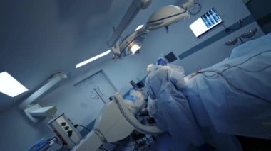 Nöroşirürji ameliyathanesinde özel ekipmanlar var. İki doktor hastaya ameliyat sağlıyor. Seçici odak.