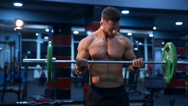 英俊的男性运动员 完美的体格训练 体育馆里有杠铃 强壮的身体和完美的腹肌 慢动作 — 图库视频影像
