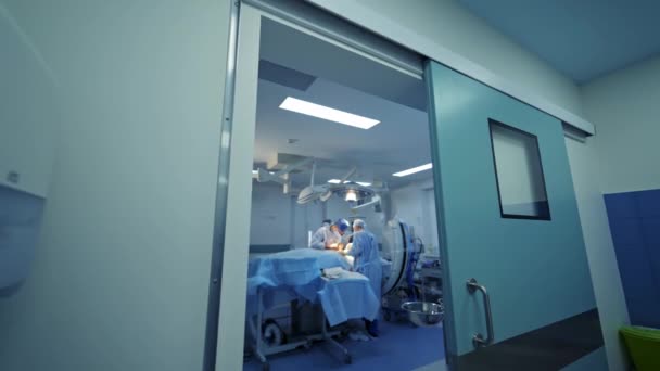 Grupa Chirurgów Wykonująca Operację Lekarze Niebieskim Mundurze Medycznym Sali Operacyjnej — Wideo stockowe