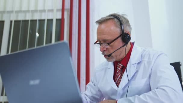 Orvos Műtőben Fülhallgatóval Laptopja Előtt Távorvoslás Fogalma — Stock videók