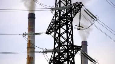 Elektrik direğine karşı karanlık fabrika boruları. Dumanlı fabrika boruları. Kirli duman bacalardan havaya yayılıyor. Hava görüntüleme videosu.