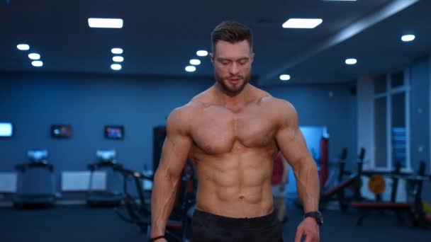 肌肉运动员强壮的人在经过大量训练后在体育馆里行走 完美的躯干和强壮的腹肌 英俊的男性 赤身裸体 — 图库视频影像
