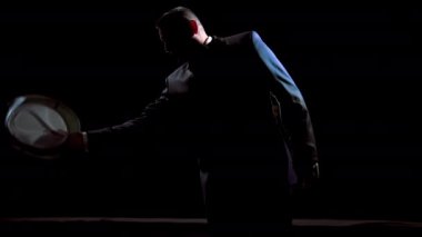 Sahnedeki aktör. Sahne ışıkları altında tiyatroda sahne alan takım elbiseli bir adamın karanlık silüeti. Sahneden görünüm.