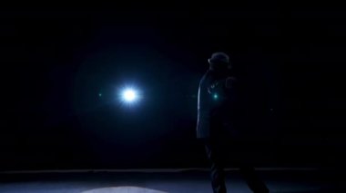Karanlıkta sahnede kostümlü son sınıf öğrencisi. Tiyatrodaki gösteri sırasında şapkalı aktif bir adam sahnede dans ediyor..
