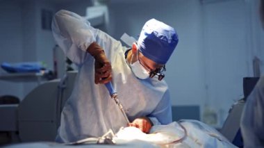 Nöroşirürji ameliyathanesinde deneyimli bir cerrah. Güncel aletleri elinde tutuyor. Önlüklü doktor, lateks gözlüklü ve ameliyat gözlüklü..