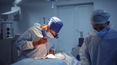 Profesyonel cerrahların acil beyin cerrahisi operasyonu. Nöroşirürji odasında doktor var. İşletim tablosunun üzerindeki seçili ışık.