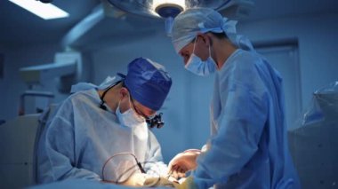 Modern ameliyathanede tıbbi uzmanlar. İki erkek cerrah beyin cerrahisi aletleriyle çalışıyor. Önlüklü doktorlar..
