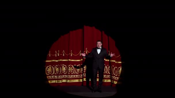 劇場でのステージでの発表 1人の人の明るいライト 黒いスーツの男が講堂に出演する — ストック動画