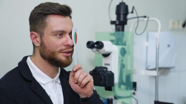 Homem Bonito Verifica Visão Clínica Oftalmológica Quadro Experimental Optometrist Conceito — Vídeo de Stock