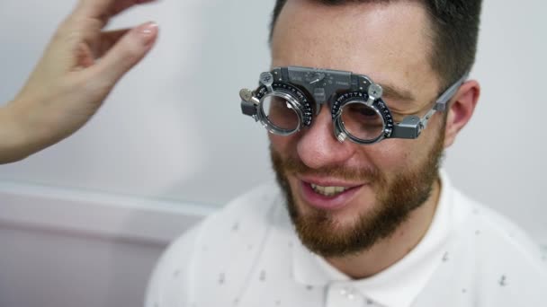 眼科クリニックでハンサムな男 男性患者の視力補正のための代替レンズ付きの特別なテストガラス — ストック動画