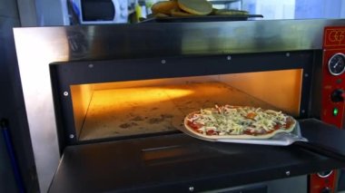 Bir kafedeki Tahta Masa 'da Taze Hazırlanmış Pizza. Modern bir restoranın arka planında iştah açıcı sıcak pizza..