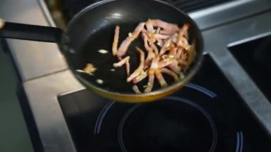 Kahvaltıda pastırma pişiriyorum. Şef tavada kızarmış pastırma yapıyor. Hamburger için malzemeler. Kapat..