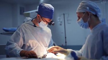 Modern klinikte ameliyat süreci. Ameliyathanede ameliyat ekipmanlarıyla bir grup cerrah. Doktorun ellerinde tıbbi çekiç.