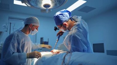 Beyin cerrahları ameliyathanede. Cerrahi gözlüklü dikkatli doktorlar ameliyat sağlıyor. Seçici odak.
