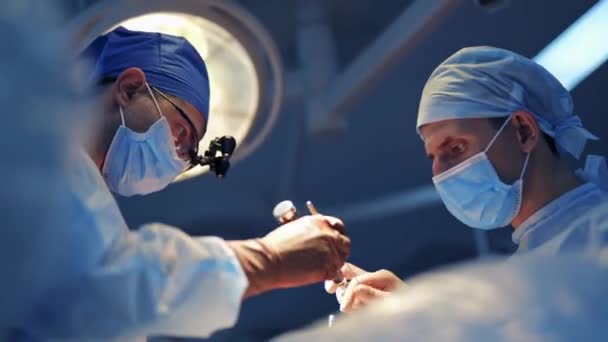안경의 신경외과 의사는 수술을 제공합니다 보조원들은 의사들을 도와줍니다 수술실에서 조심스러운 — 비디오