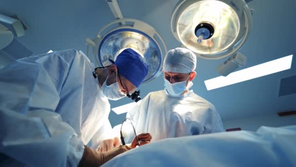 Specjaliści Nowoczesnej Sali Operacyjnej Lekarze Wykonują Zabieg Patrząc Proces Monitorze — Wideo stockowe