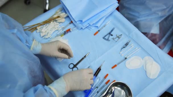 医学は手術器具を選択する スカルペルやハサミ シリンジ クランプ 操作のための器械 上からのビデオ — ストック動画