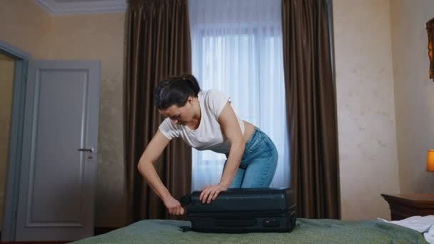 若い女性がホテルの部屋にバッグを詰め込んでいる 家に帰る時間だ 職業時間コンセプト — ストック動画